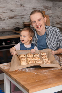 Father and child cooking on the kitchen with fun. family baking cinnabons