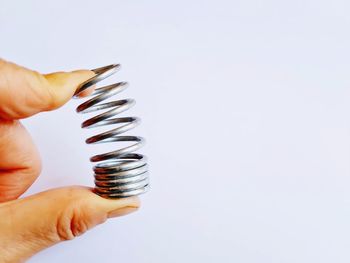 Close-up of hand holding trophy against white background