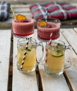 Close-up of cocktails in vintage glasses and jars on white pallet table in bar