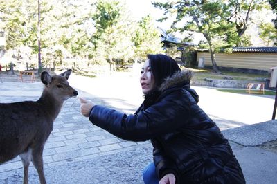 Woman gesturing by deer