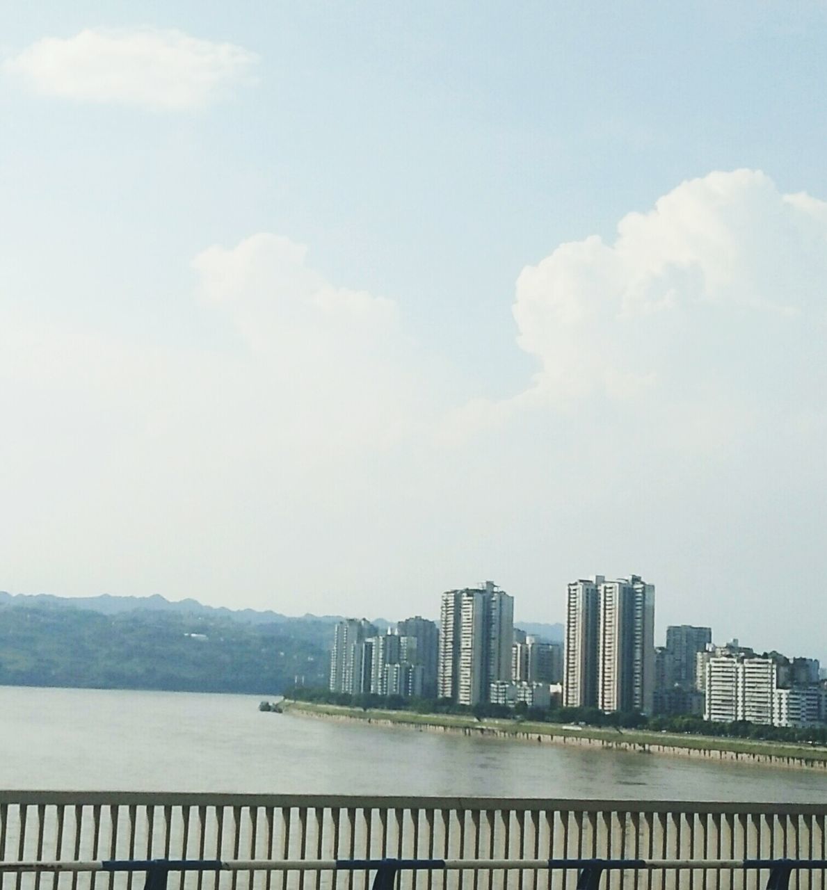 architecture, built structure, water, building exterior, sky, skyscraper, day, railing, cloud - sky, city, outdoors, waterfront, no people, river, cityscape, urban skyline, modern, nature