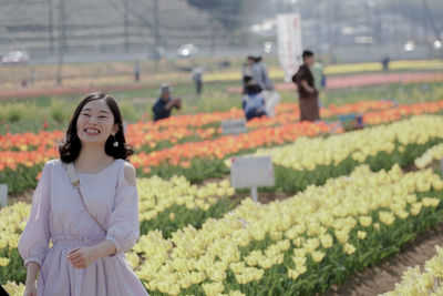 Rear view of woman standing on flowering plants