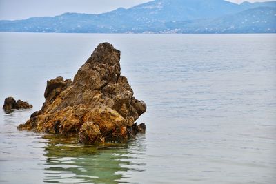 Rock formation in sea against sky