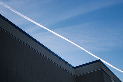 Low angle view of vapor trail against blue sky