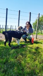 Woman with dog on field against clear sky