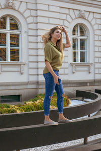 Full length of woman standing against window