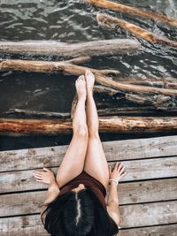 Low section of woman lying on wood