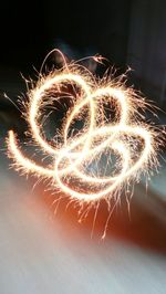 Close-up of illuminated fireworks against sky at night