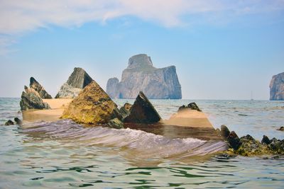 Rocks in sea against sky