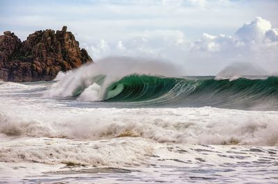 Waves on sand against sky