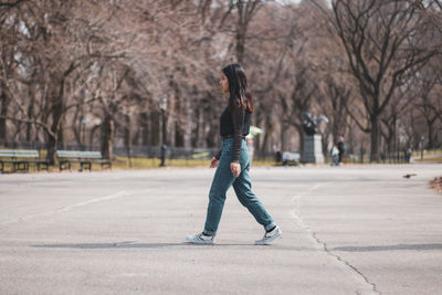 Young woman walking on road in city