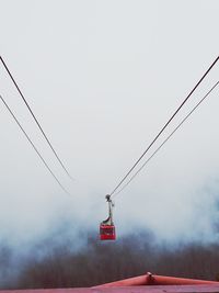 Low angle view of cable hanging against sky