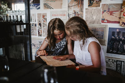 Girls reading menu in cafe