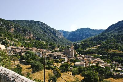 Scenic view of townscape and mountains against clear sky
