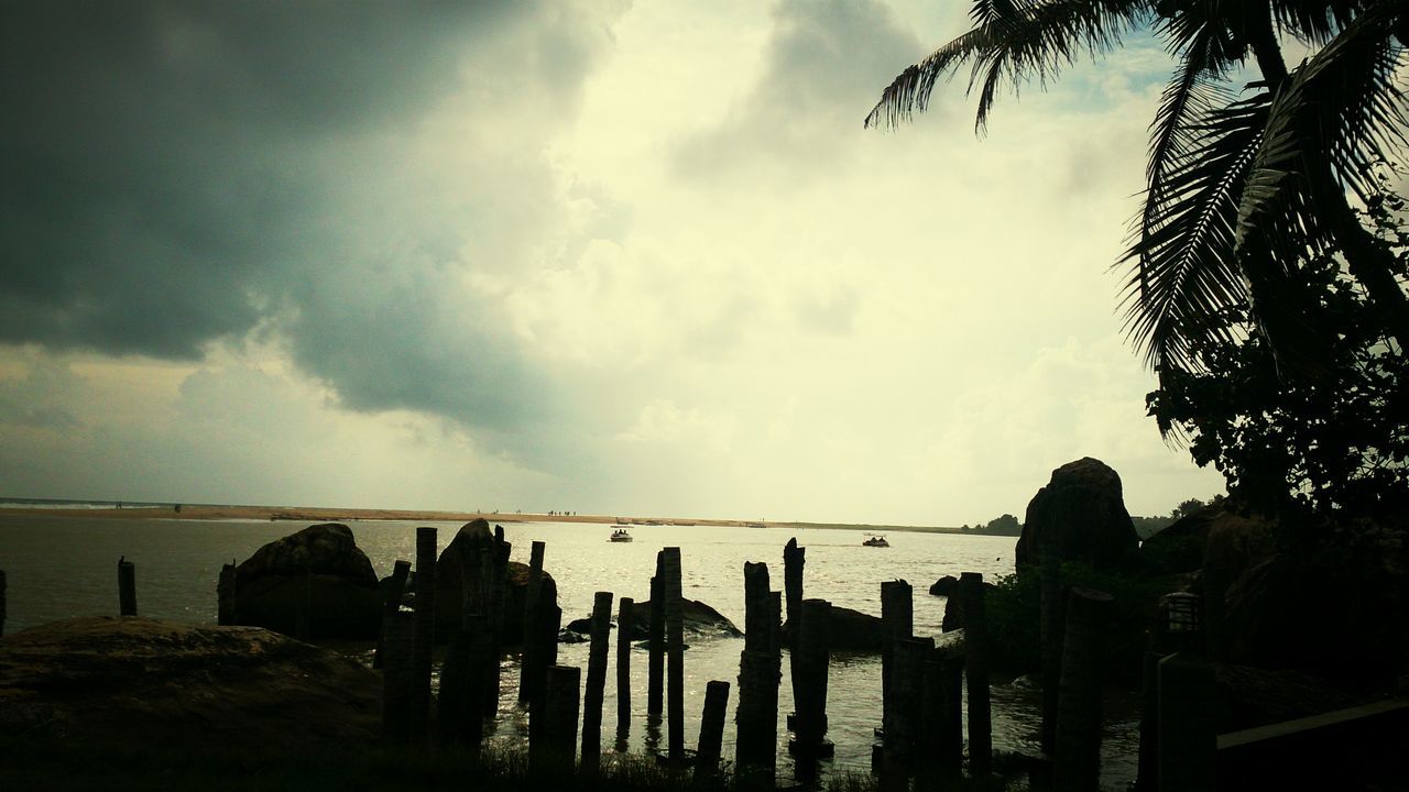 sky, cloud - sky, water, sea, tranquility, tranquil scene, scenics, cloudy, horizon over water, nature, beauty in nature, fence, cloud, silhouette, beach, railing, sunset, idyllic, outdoors, wood - material