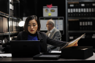 Portrait of young woman using laptop at office