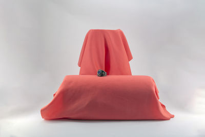 Close-up of red umbrella on table against white background