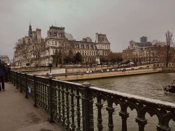 Bridge over river against buildings in city