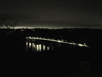 Silhouette illuminated bridge against sky at night