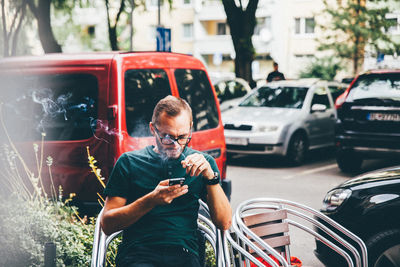 Full length of man using mobile phone in bus