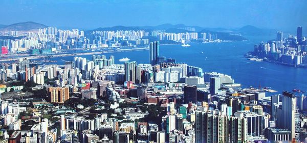 High angle view of city by sea against sky