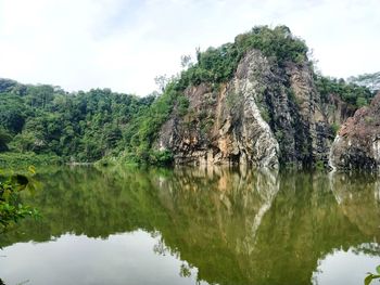 Scenic view of lake by trees against sky