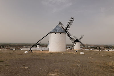 Spanish traditional white windmill on land against sky