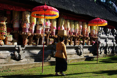 Rear view of woman walking in temple against building