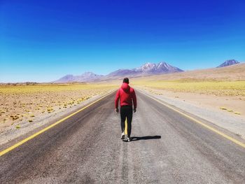 Rear view of man on road against sky