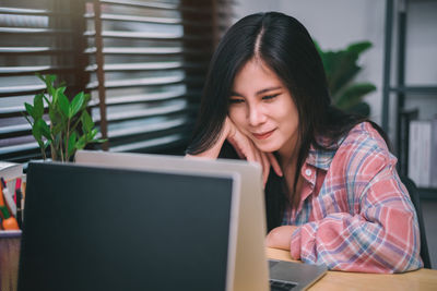 Young woman using laptop at office