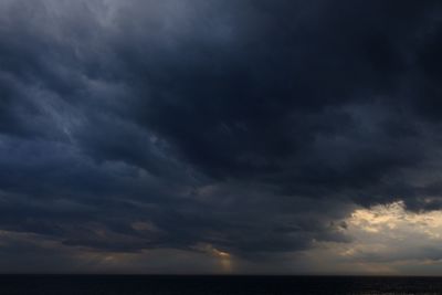 Scenic view of sea against storm clouds