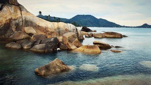 Scenic view of rocks in sea against sky