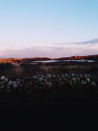 Scenic view of land against sky during sunset