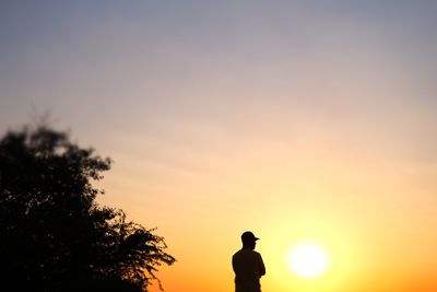 Low angle view of silhouette man standing against sky during sunset