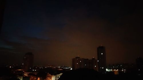 Illuminated buildings in city against sky at night