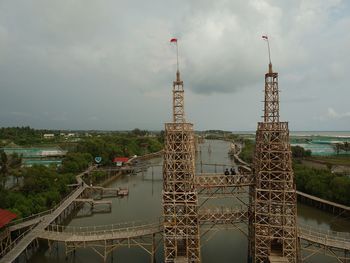 Aerial view of bridge over city against cloudy sky