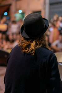 Rear view of man wearing hat standing in city