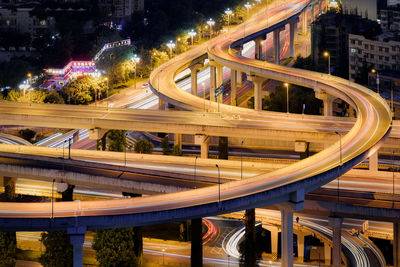 High angle view of light trails on highways in city at night