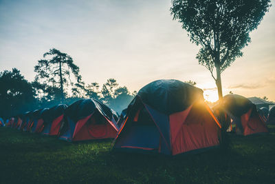 Tent on field against sky during sunset