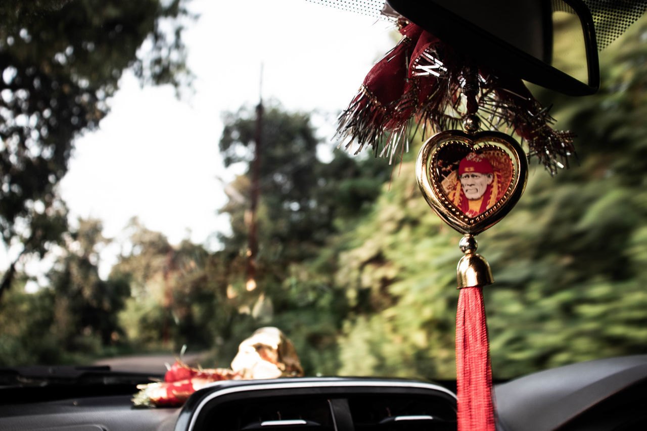 CLOSE-UP OF RED WINE HANGING FROM CAR