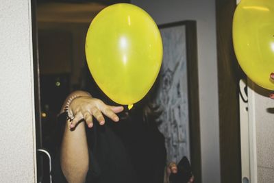 Close-up of woman with yellow balloons