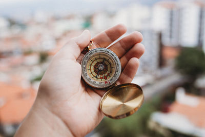 Cropped hand holding navigational compass