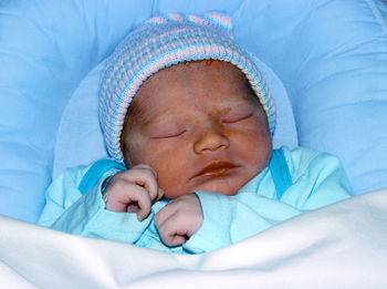 Baby boy sleeping on bed at home
