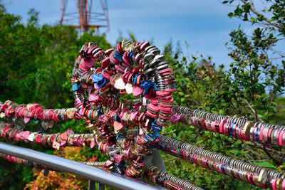 Close-up of multi colored padlocks hanging on a love heart shaped cable