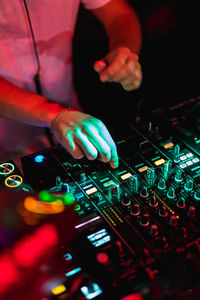 Midsection of dj playing music with sound mixer
