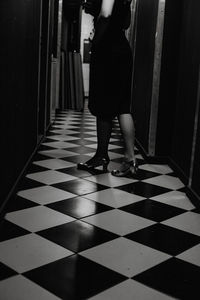 Low section of woman standing on tiled floor at home