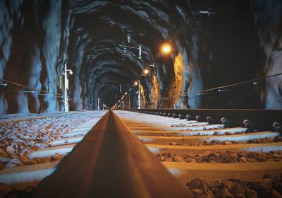 Surface level of railroad tracks in illuminated tunnel