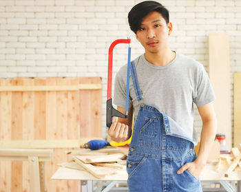 Portrait of man standing against wall at home