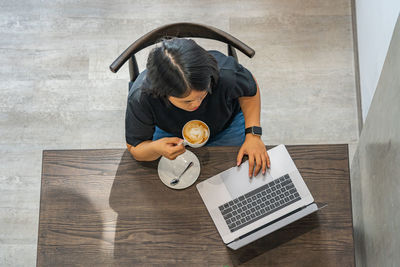 High angle view of woman using laptop on table