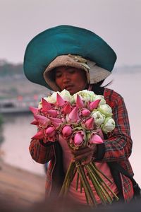 Young woman holding bunch of flowers
